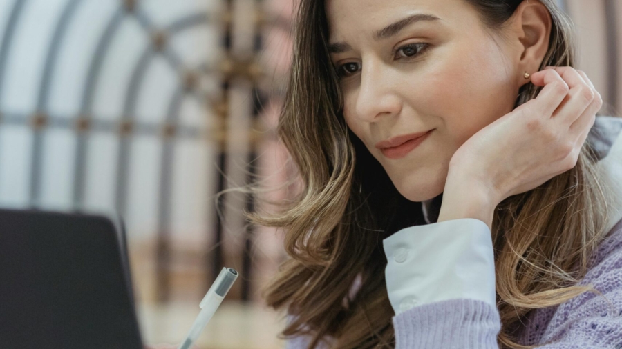 positive-woman-working-on-laptop-and-taking-notes